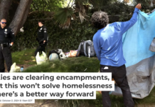 Police officers watch a homeless man follow their order to break down his tent in Venice, Calif., in July 2024. Genaro Molina/Los Angeles Times via Getty Images